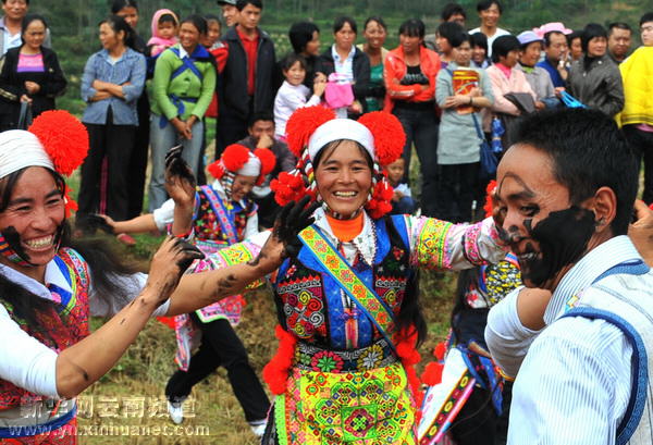 城子古村的彝族群众在进行“摸黑脸”娱乐活动（10月18日摄）