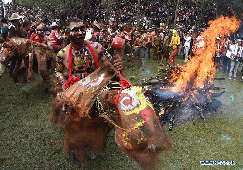 Men of Yi ethnic group ride dummy horses beside a bonfire during the annual fire worshipping festival, which falls on the third day of the second month in the Chinese lunar calendar at Xiyi Township under Mile City, southwest China