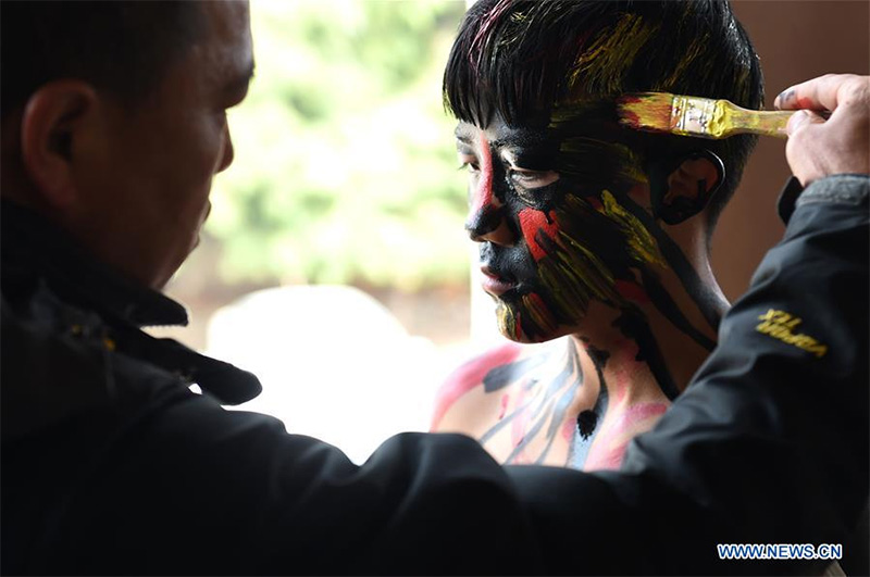 A young man get himself painted in preparation for local Yi people's annual fire worshipping festival, which falls on the third day of the second month in the Chinese lunar calendar at Xiyi Township under Mile City, southwest China's Yunnan Province, Marc A young man get himself painted in preparation for local Yi people