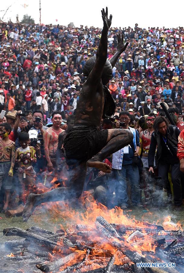 A man of Yi ethnic group jumps over a bonfire to drive out ill fortune during the annual fire worshipping festival, which falls on the third day of the second month in the Chinese lunar calendar at Xiyi Township under Mile City, southwest China